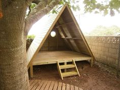 a small wooden structure in the middle of a tree with stairs leading up to it