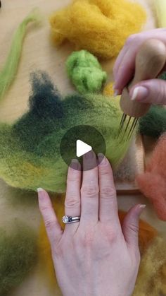 someone is making something out of wool with their fingers and thumbnails on the table