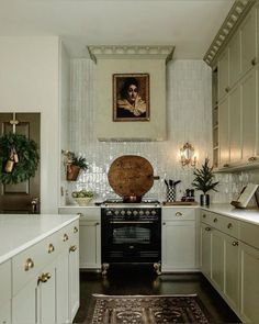 a kitchen with white cabinets and an antique rug on the floor in front of the stove