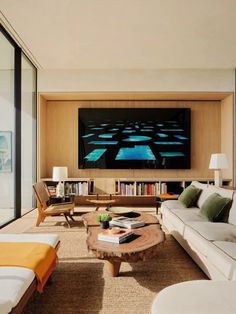 a living room filled with furniture and a flat screen tv mounted to the side of a wall