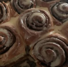 a pan filled with cinnamon rolls covered in icing