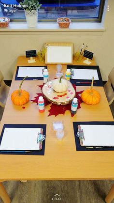 the table is set with place settings for two people to sit at and have pumpkins on it