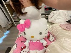 a woman holding a hello kitty stuffed animal