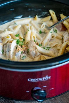 a crock pot filled with pasta and chicken