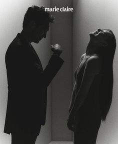 a man and woman standing next to each other in front of a wall with the words marie claire on it