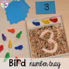 the bird number tray is filled with colorful birds and numbers to make it look like they are