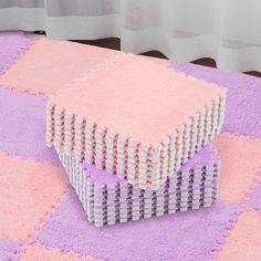 a pink and purple area rug on the floor with several rows of white boxes stacked together