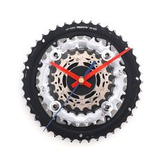 a clock made out of bicycle parts on a white surface with red hands and blue tips