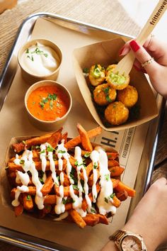 a tray with some food on it and dipping sauces in bowls next to it