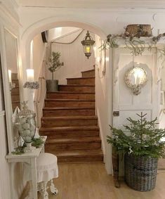 an entry way with stairs and potted plants