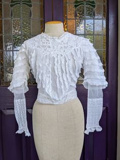 "Beautiful white cotton turn-of-the-century blouse in lace and net and row upon row of little ruffles.  It fastens in back with snaps. A frothy confection perfect for a wedding, period production, or just worn with jeans, the blouse is in excellent condition. A small wearable size, the measurements are approx: 15 1/2\" across the shoulders up to 36\" bust 28\" waist 23\" sleeve length 18\" length in front 14 1/2\" in back See my entire shop collection here https://www.etsy.com/shop/RobinClaytonV Fitted Lace Blouse With Ruffles, Victorian Fitted Ruffle Blouse, Victorian Fitted Ruffled Blouse, Fitted Victorian Blouse With Ruffles, Fitted Victorian Dress With Ruffles For Vintage Events, White Victorian Blouse With Ruffles, Fitted White Victorian Blouse, White Fitted Victorian Blouse, Victorian Fitted Blouse With Lace Collar