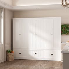 an empty room with white cabinets and wood floors