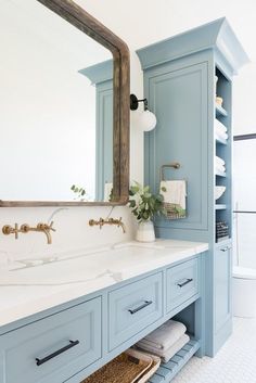 the instagram page shows an image of a bathroom with blue cabinets and white counter tops