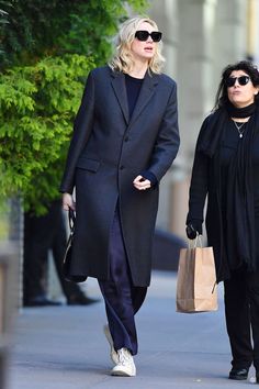 two women walking down the street carrying shopping bags