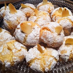 powdered sugar covered pastries sit on a glass platter, ready to be eaten