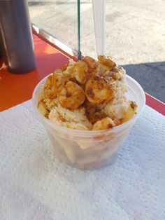 a plastic container filled with food on top of a white tablecloth next to a window