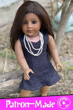 the doll is wearing a blue dress and pearls