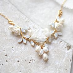 LOLITA is the perfect accessory for every special event! This floral gold necklace with freshwater pearls and Austrian crystals will glam up your look and give you the "wow" factor. Make a statement with this dazzling yet delicate piece! - Handcrafted with genuine white opal Austrian crystals- Freshwater pearls- Polymer clay flowers- Yellow gold finish is pictured. Available in rose gold, yellow gold or rhodium (silver)- Necklace pictured measures 16 inches and extends to 18 inches. Choose the l Opal And Pearl Necklace, Gold Pearl Jewelry For Mother Of The Bride, Delicate Gold Pearl Bridal Necklace, Delicate Gold Bridal Necklace With Pearls, Delicate Pearl-embellished Jewelry For Mother Of The Bride, Delicate Pearl Charm Jewelry For Mother Of The Bride, Yellow Gold Pearl-embellished Necklaces For Wedding, Feminine Yellow Gold Necklace For Wedding, Yellow Gold Pearl Necklaces For Wedding