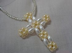 a cross made out of pearls on a white cloth