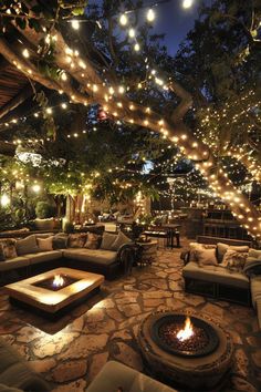 an outdoor seating area with fire pit and string lights