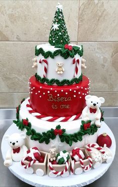 a three tiered christmas cake decorated with candy canes and teddy bears on top