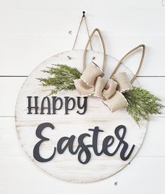 a sign that says happy easter hanging on the side of a white wooden wall with burlap bows