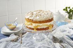 a cake sitting on top of a table covered in frosting and icing next to plates