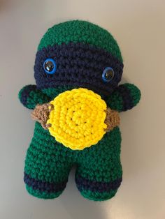 there is a crocheted stuffed animal that looks like a ninja holding a ball