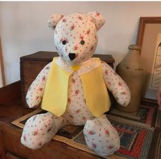 a white teddy bear sitting on top of a dresser