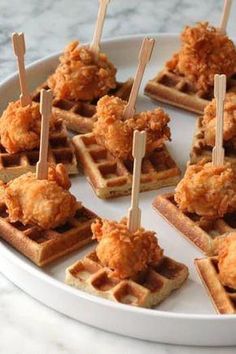 chicken and waffles on a plate with toothpicks stuck in the middle