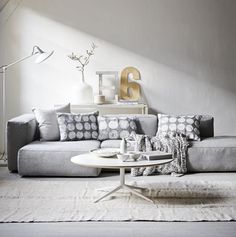 a living room filled with lots of furniture next to a white table and wall mounted clock