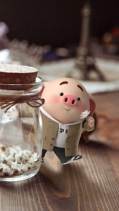 a small pig figurine sitting in front of a jar filled with popcorn