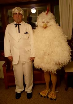 a man in a white suit standing next to a chicken wearing a tuxedo