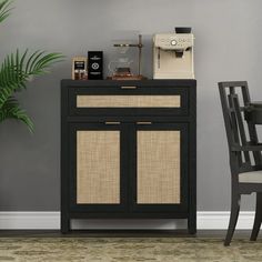 a small black cabinet sitting next to a table with a coffee maker on top of it