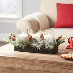 a tray with candles and christmas decorations sits on a coffee table