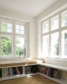 an empty room with bookshelves and windows