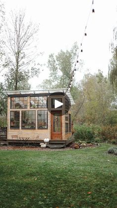 a tiny house sitting on top of a lush green field