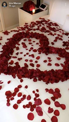 the bed is decorated with petals and candles