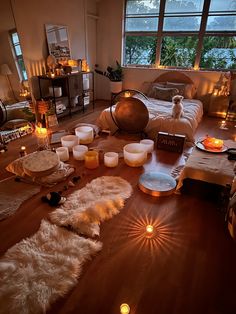 a living room filled with lots of candles next to a bed covered in white fur