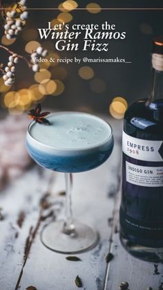 a bottle of gin next to a glass filled with blue liquid and garnish