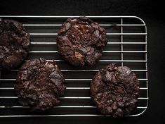 four chocolate cookies sitting on top of a cooling rack