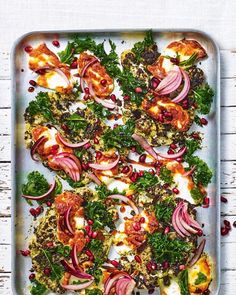 a tray filled with meat and veggies on top of a white wooden table