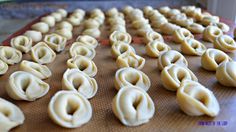 dumplings are lined up on a baking sheet and ready to be cooked in the oven