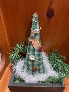 a small christmas tree made out of fabric and wood with a price tag on it