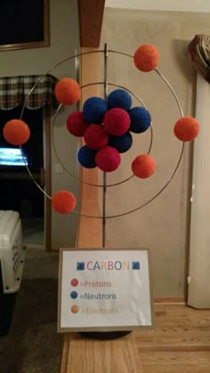 a table with a sign that says carbon and some balls in the air on it