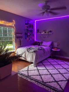 a bed room with a neatly made bed and purple lighting