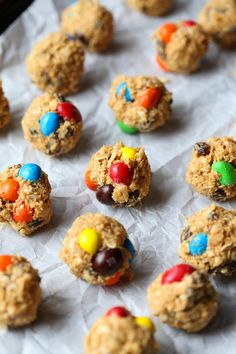 cookies with m & m's and candy are on a sheet of wax paper