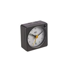 a small black clock with yellow hands on a white background, it appears to be an alarm clock