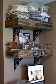 two wooden shelves with baskets on them above a computer