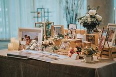 a table topped with pictures and flowers next to candles